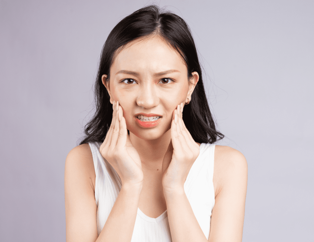 Woman Experiences Wisdom Tooth Discomfort As She Cradles The Side Of Her Face With Both Hands 